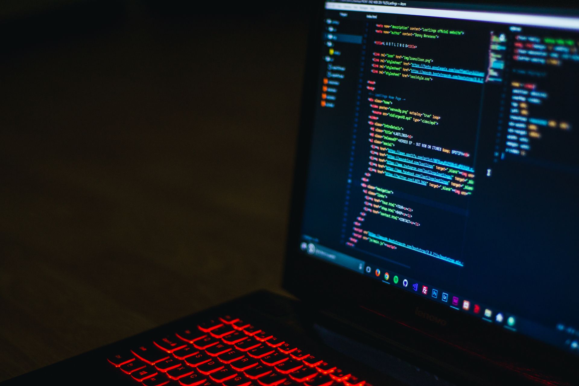 Lenovo-Notebook mit HTML-Code und roter Tastaturbeleuchtung