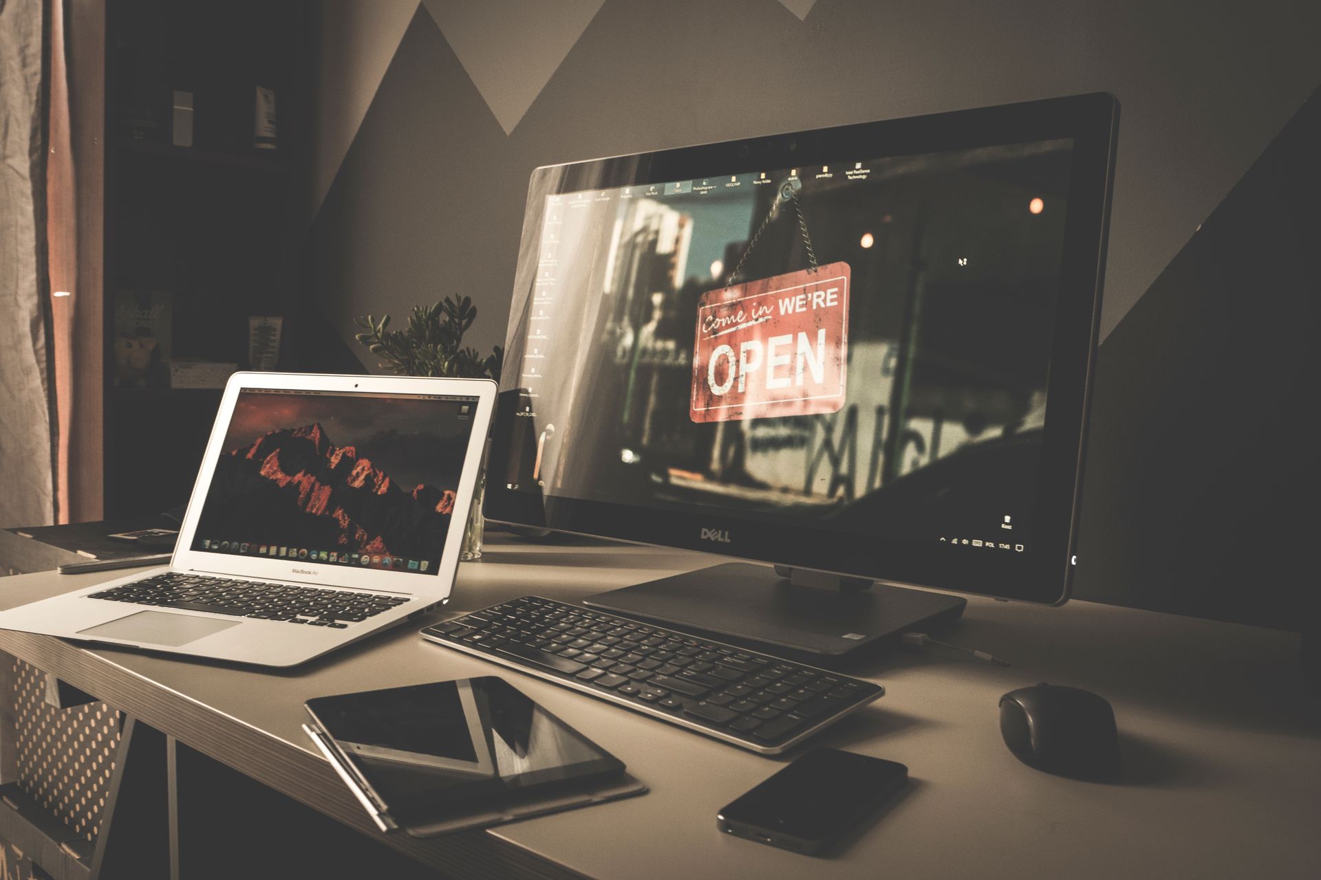 MacBook argenté ouvert sur un bureau avec moniteur Dell et clavier