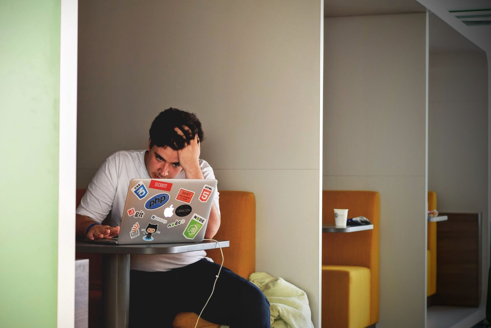 MacBook с наклейками разработчика на крышке, экран с кодом