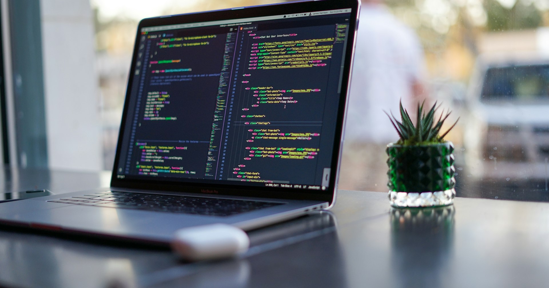 MacBook Pro with VS Code open on a chatbot HTML and JavaScript project