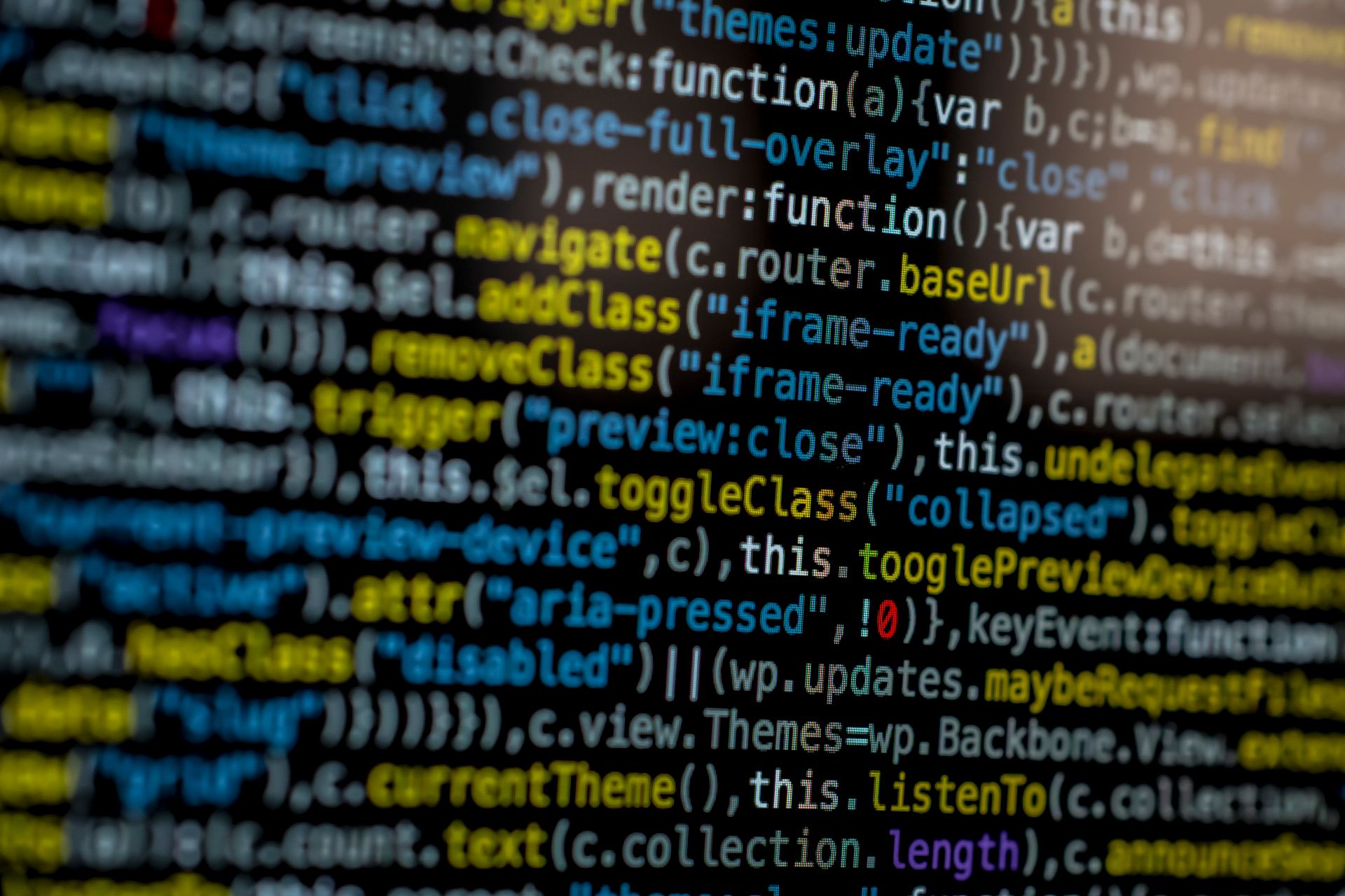 Крупный план цветного JavaScript-кода на тёмном экране